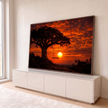 Árvore em silhueta com balanço de madeira diante do sol se pondo em céu laranja intenso, quadro decorativo