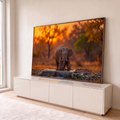 Elefante filhote bebendo água em bebedouro de pedra na savana ao pôr do sol laranja, quadro decorativo