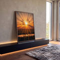 Silhuetas de antílopes bebendo água em lago sob raios de sol laranja na savana, quadro decorativo