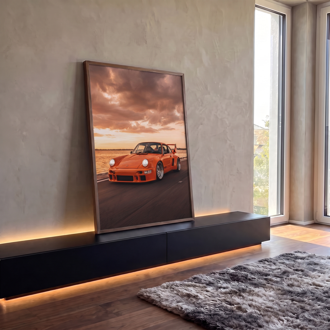 Porsche 911 laranja com aerofólio em estrada litorânea sob céu de pôr do sol, quadro decorativo