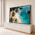 Vista aérea de praia tropical com palmeiras, areia clara, rochas e mar turquesa, quadro decorativo