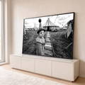 Menino vestido de palhaço com chapéu de pompom diante de tenda de circo em preto e branco, quadro decorativo