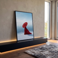 Mulher de vestido e chapéu vermelho gigante à beira de lago de sal sob céu azul, quadro decorativo