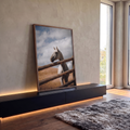 Cavalo branco atrás de cerca de madeira rústica com céu nublado e colinas ao fundo, quadro decorativo