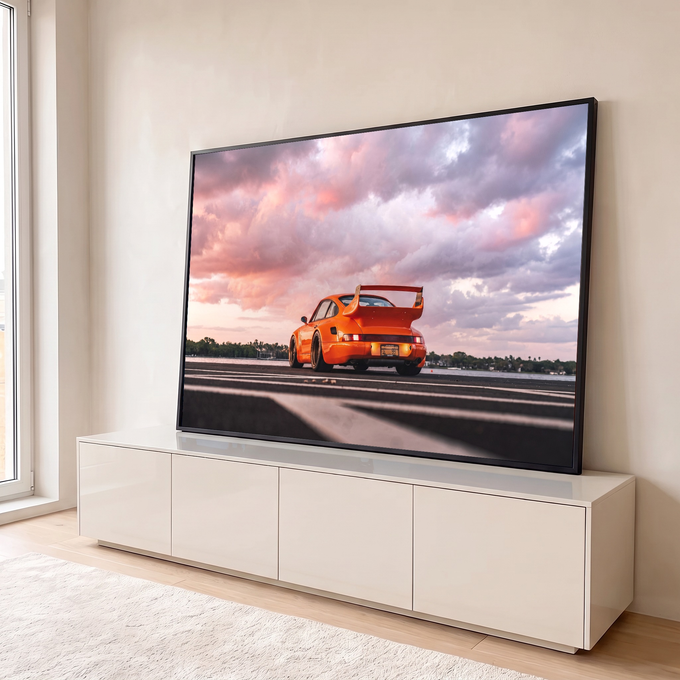 Porsche 911 laranja widebody com aerofólio sob céu de nuvens rosa ao pôr do sol, quadro decorativo