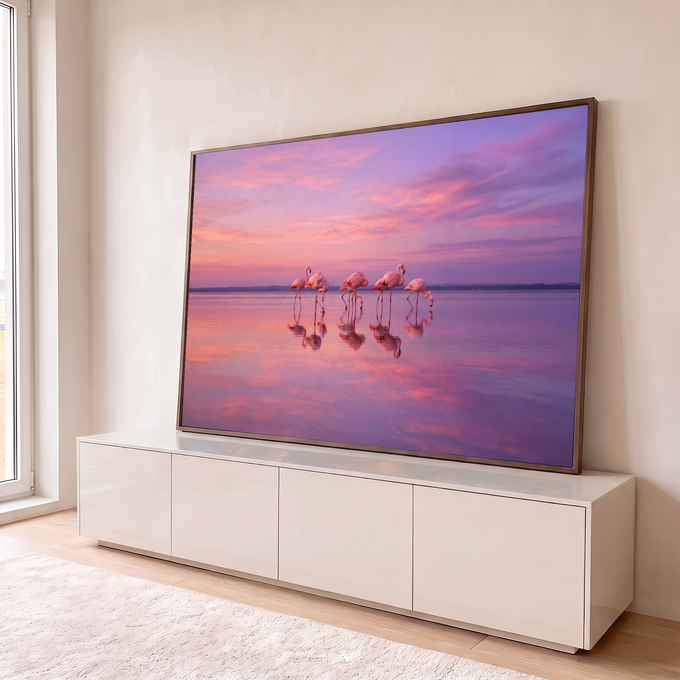 Flamingos cor-de-rosa refletidos em lago calmo sob céu rosa e lilás ao pôr do sol, quadro decorativo