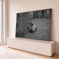 Quadro Decorativo Grande Cachorro e Criança para Sala Preto | quadros decorativos para sala | cachorro deitado apoiado no joelho de criança em beco de pedra, preto e branco | em Quadros para Sala | Porao dos Quadros
