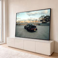Quadro Decorativo Grande Carro Esportivo Skyline para Sala | quadros decorativos para sala | carro esportivo preto visto de trás em estacionamento com skyline urbano ao fundo | em Quadros para Sala | Porao dos Quadros