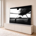 Quadro Decorativo Grande Avião e Carro para Sala Preto | quadros decorativos para sala | avião camuflado e carro esportivo clássico em pátio com neblina em preto e branco | em Quadros para Sala | Porao dos Quadros