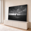 Menina sozinha num balanço em campo aberto sob nuvens de tempestade, foto preto e branco, quadro decorativo