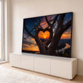 Árvore com galhos em forma de coração emoldurando pôr do sol sobre montanhas e rio, quadro decorativo