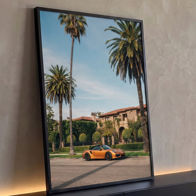 Porsche conversível dourado estacionado diante de mansão mediterrânea entre palmeiras, quadro decorativo