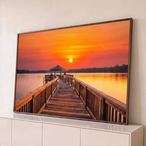 Píer de madeira com quiosque sobre lago calmo sob céu laranja de pôr do sol, quadro decorativo