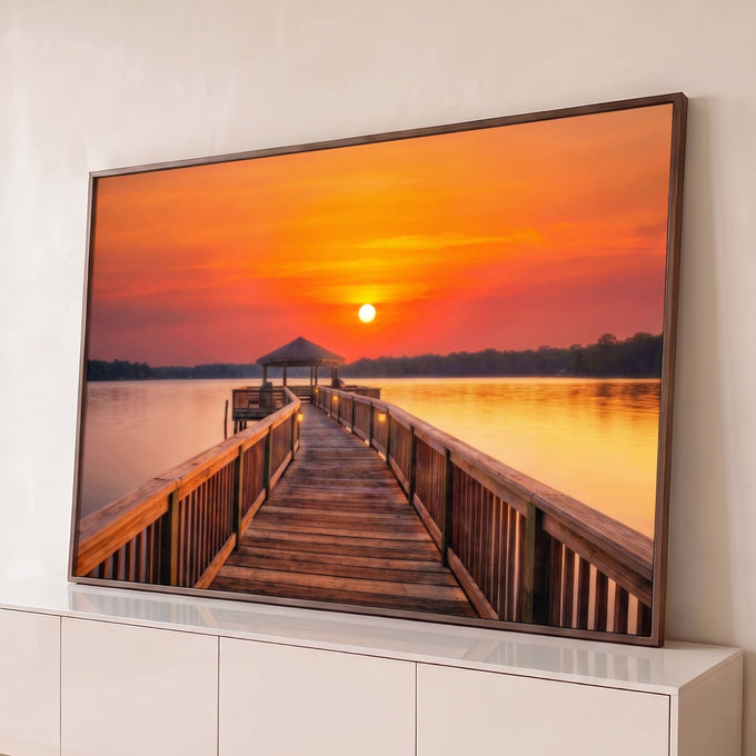 Píer de madeira com quiosque sobre lago calmo sob céu laranja de pôr do sol, quadro decorativo