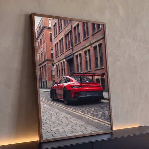 Quadro Decorativo Grande Carro de Pista para Sala | quadros decorativos para sala | carro esportivo vermelho com aerofólio preto em rua de paralelepípedos e prédio de tijolos | Porao dos Quadros