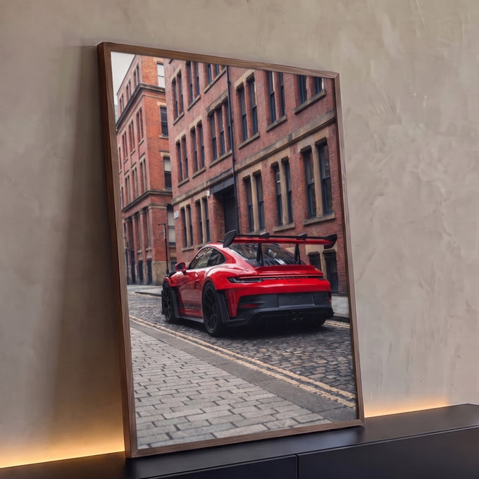 Quadro Decorativo Grande Carro de Pista para Sala | quadros decorativos para sala | carro esportivo vermelho com aerofólio preto em rua de paralelepípedos e prédio de tijolos | Porao dos Quadros