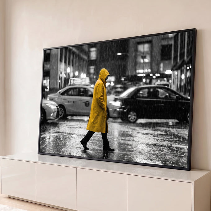 Pessoa de capa amarela atravessando rua chuvosa com táxis em cena preto e branco, quadro decorativo