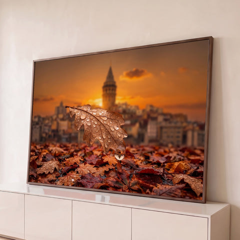 Folha de carvalho com gotas de chuva sobre folhas secas, torre ao fundo no pôr do sol laranja, quadro decorativo