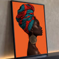 Quadro Decorativo Mulher Africana de Turbante Estampado | quadros decorativos para sala | mulher negra de perfil com turbante estampado vermelho e azul sobre fundo laranja | Porao dos Quadros
