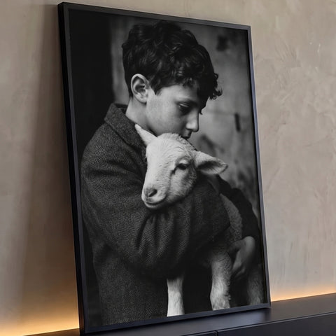 Fotografia preto e branco de menino de cabelo cacheado abraçando um cordeiro, quadro decorativo