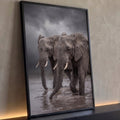 Dois elefantes africanos cruzando rio barrento sob céu de tempestade em tons de cinza, quadro decorativo