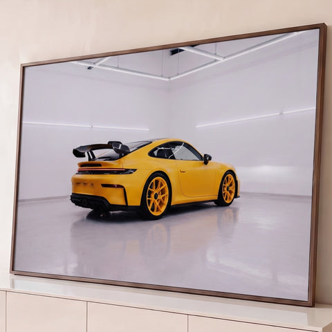 Porsche 911 GT3 amarelo com aerofólio em estúdio branco iluminado e piso espelhado, quadro decorativo