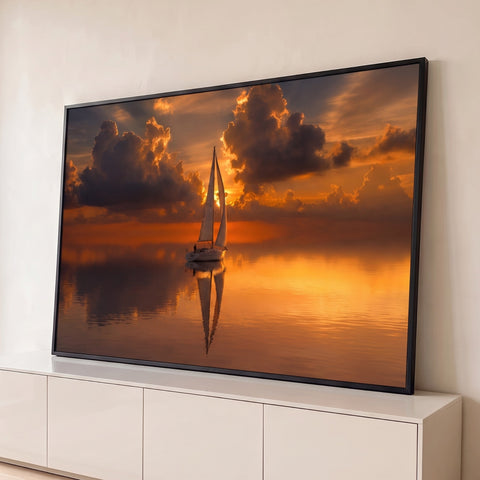 Veleiro solitário refletido no mar calmo sob nuvens dramáticas e céu laranja ao pôr do sol, quadro decorativo