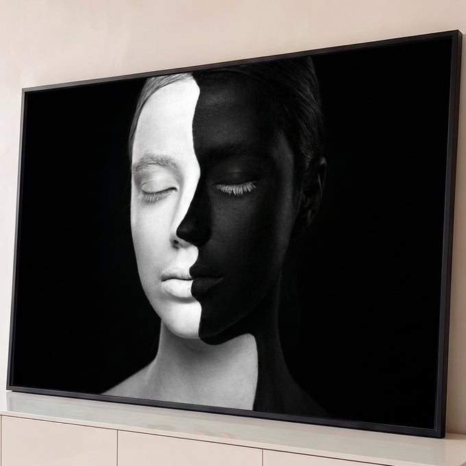 Rosto feminino metade branco metade preto em body paint, olhos fechados, fundo preto, quadro decorativo