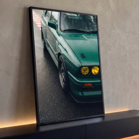 Carro esportivo verde retrô com faróis amarelos e gotas de chuva em pista molhada, quadro decorativo