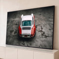 Porsche 911 clássico vermelho e branco visto de cima sobre piso de concreto cinza, quadro decorativo