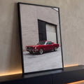 Mustang fastback clássico vermelho estacionado diante de parede de tijolos bege, quadro decorativo