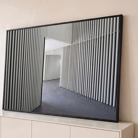 Fotografia de interior com ripas verticais claras, vão aberto e piso de concreto cinza, quadro decorativo