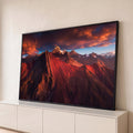 Cordilheira dos Andes vermelha com picos nevados sob céu de nuvens alaranjadas, quadro decorativo