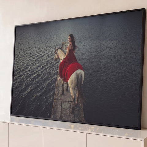 Mulher de vestido vermelho montada em cavalo branco sobre píer de pedra em lago escuro, quadro decorativo