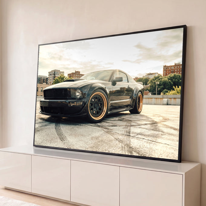 Mustang preto com rodas bronze sobre marcas de pneu em terraço urbano ao entardecer, quadro decorativo