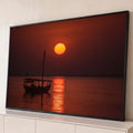 Veleiro árabe em silhueta sob sol laranja no mar calmo com reflexo dourado, quadro decorativo