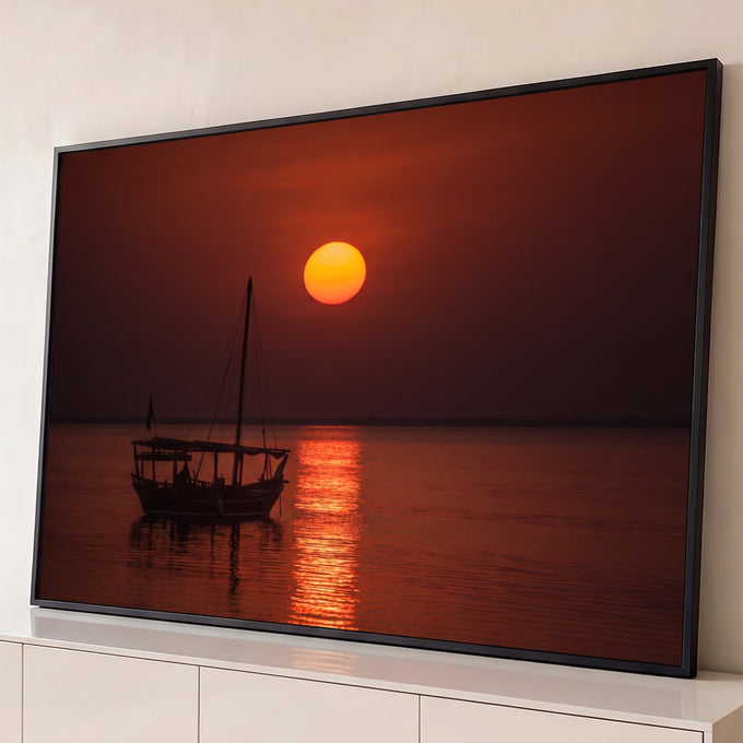 Veleiro árabe em silhueta sob sol laranja no mar calmo com reflexo dourado, quadro decorativo