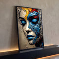 Rosto de mulher de olhos fechados fragmentado em lascas azuis, bege e toques amarelos, quadro decorativo