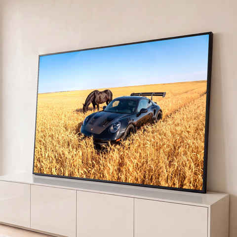 Porsche preto esportivo com aerofólio e cavalo negro pastando em campo de trigo dourado, quadro decorativo