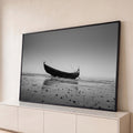 Fotografia preto e branco de barco de madeira na areia molhada da praia sob névoa, quadro decorativo
