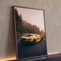 Carro esportivo amarelo em estrada de montanha com névoa e pinheiros ao amanhecer, quadro decorativo