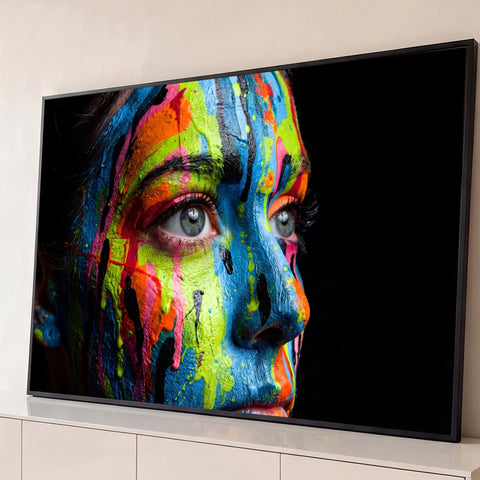 Rosto de mulher pintado com tinta azul, verde e laranja escorrendo sobre fundo preto, quadro decorativo