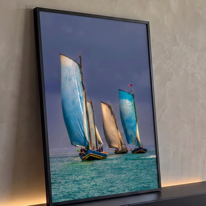 Barcos a vela com velas azuis e bege navegando em mar turquesa sob céu tempestuoso, quadro decorativo