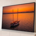Quadro Decorativo Grande Veleiro Iluminado para Sala Laranja | quadros decorativos para sala | veleiro de dois mastros iluminado com luzes, ancorado em mar calmo ao pôr do sol laranja | Porao dos Quadros