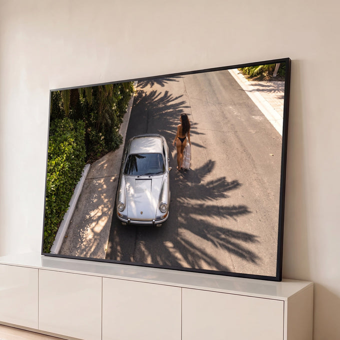 Porsche 911 prateado visto do alto em rua com sombras de palmeiras e mulher de biquíni, quadro decorativo