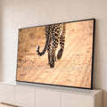 Quadro Decorativo Grande Leopardo Caminhando para Sala Bege | quadros decorativos para sala | leopardo visto de trás caminhando em estrada de terra com cauda enrolada | Porao dos Quadros