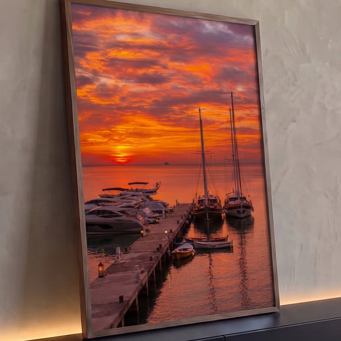 Pôr do sol laranja sobre marina com veleiros, iates e barcos no píer refletidos no mar, quadro decorativo