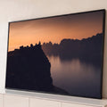 Silhueta no penhasco diante de fiorde e montanhas ao pôr do sol laranja, quadro decorativo