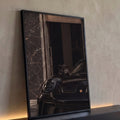 Filhote de pantera negra sobre capô de Porsche preto diante de parede de mármore escuro, quadro decorativo