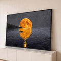 Quadro Decorativo Grande Lua Dourada para Sala Laranja | quadros decorativos para sala | lua cheia laranja refletida no mar com pequeno barco e penhascos ao fundo | Porao dos Quadros